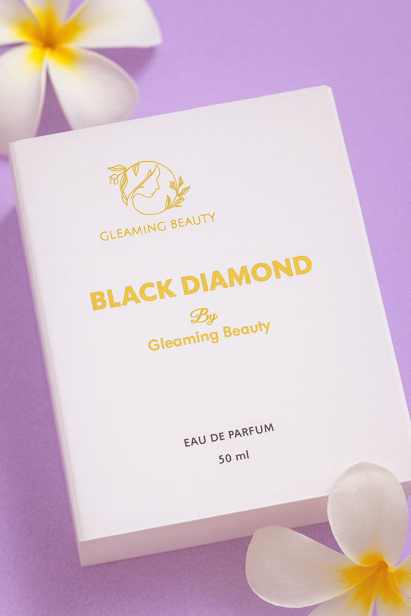 Gleaming Beauty Black Diamond perfume packaging on a purple background with flowers.